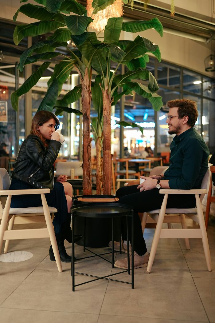 Female professor and man having a conversation in a cafe, highlighting debate over evidence-based decision to stop dating men. Female professor and man having a conversation in a cafe, highlighting debate over evidence-based decision to stop dating men.