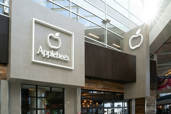 Applebee’s restaurant exterior with large modern logo and glass windows showcasing interior dining area.