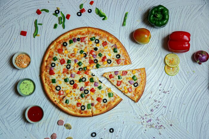 Vegetable pizza with olives, bell peppers, and sauces, contrasting with the idea of shrimp jello as a strange dish. Vegetable pizza with olives, bell peppers, and sauces, contrasting with the idea of shrimp jello as a strange dish.