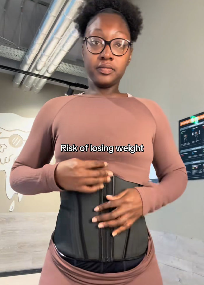 Woman wearing waist trainer demonstrating a trick to hide loose skin on her belly after weight loss