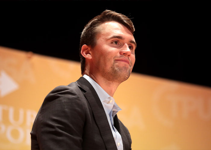 Young man in a dark blazer looking attentive during a public speaking event about acting and gestures. Young man in a dark blazer looking attentive during a public speaking event about acting and gestures.