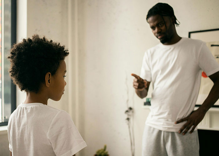 Man reacting to teen daughter’s relationship in a serious discussion inside a home setting.