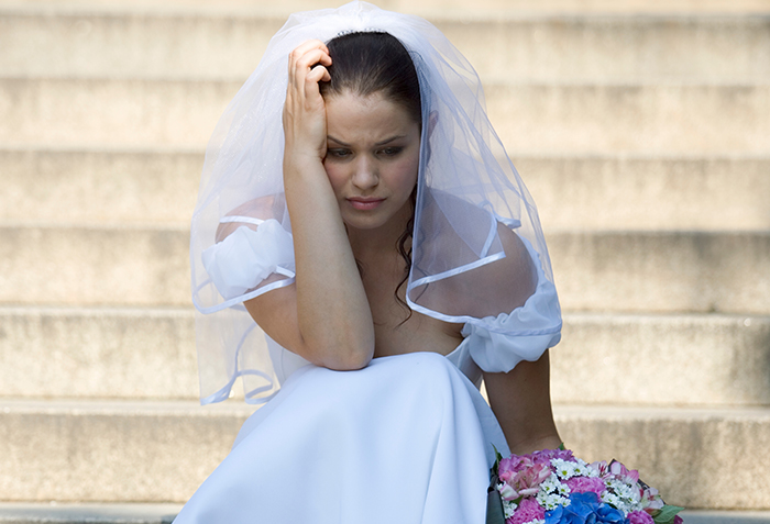 Bride in wedding dress sitting on steps looking upset, symbolizing wedding vows written with ChatGPT and AI issues. Bride in wedding dress sitting on steps looking upset, symbolizing wedding vows written with ChatGPT and AI issues.