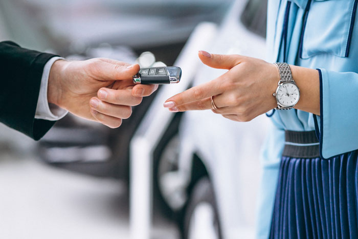 Close-up of two people exchanging a car key, illustrating a moment in wildest family drama shared online.