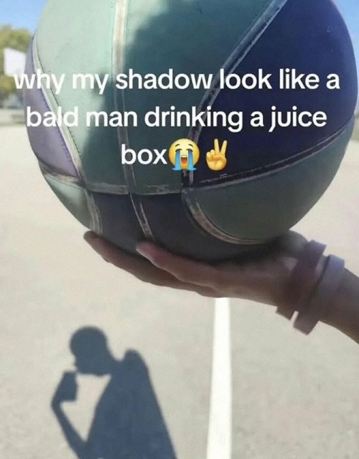 Shadow of a person drinking from a juice box next to a basketball held in a hand, a popular pic that goes hard.