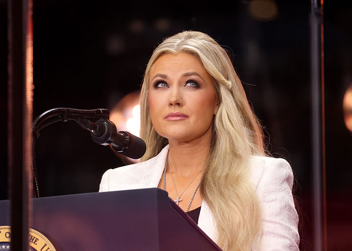 Erika Kirk speaking at a podium, exhibiting expressive gestures that fuel speculation about her acting style while crying. Erika Kirk speaking at a podium, exhibiting expressive gestures that fuel speculation about her acting style while crying.