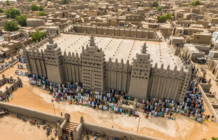 Aerial view of a crowded mud-brick mosque in one of the poorest countries facing severe hardship.