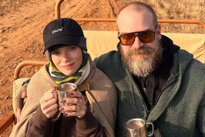 Lily Allen and a bearded man sitting outdoors holding metal cups, Lily Allen’s CFDA fashion look sparking debate online.