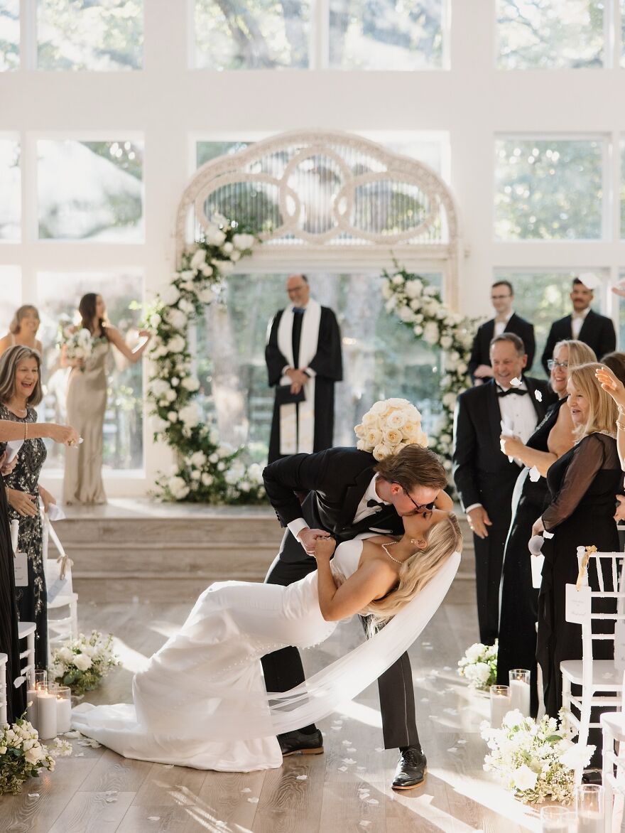 Bride and groom sharing a romantic kiss during their wedding ceremony, highlighting types of kisses in culture and stories.