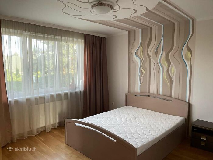 Modern bedroom with unique wall design and large window, part of wild real estate listings to attract buyers.