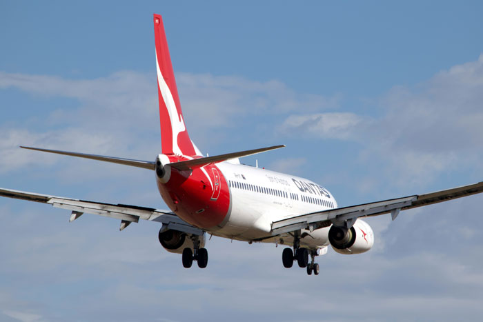 Commercial airplane with landing gear down flying in the sky representing pilots’ terrifying close calls mid-flight.