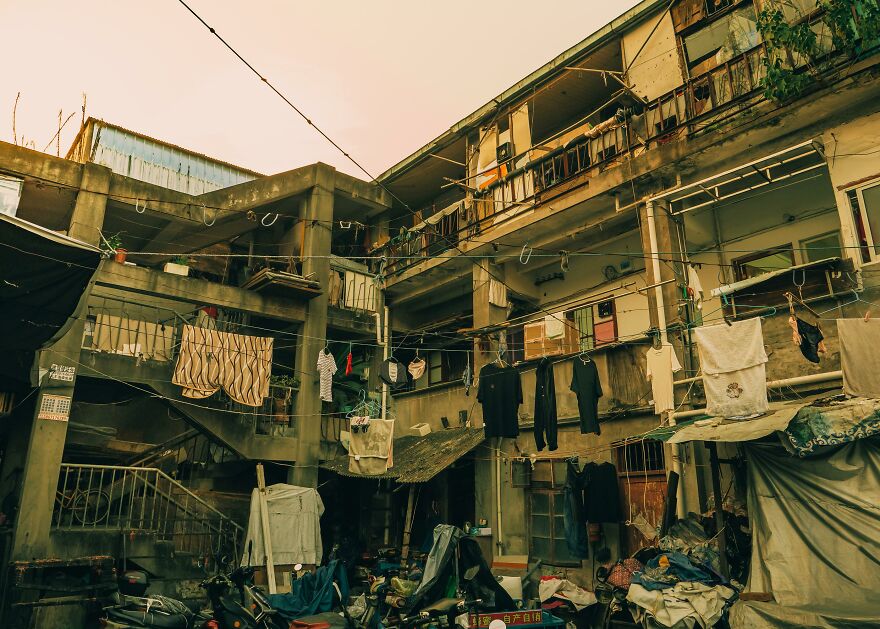 Worn exterior of an urban Asian apartment complex showing daily life, challenging outdated Asian stereotypes in the modern world.