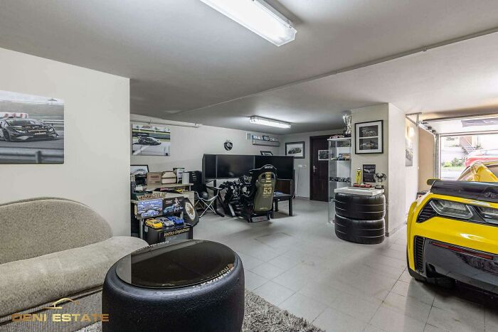 Modern garage interior with a yellow sports car and a gaming setup, part of wild real estate listings to sell properties.