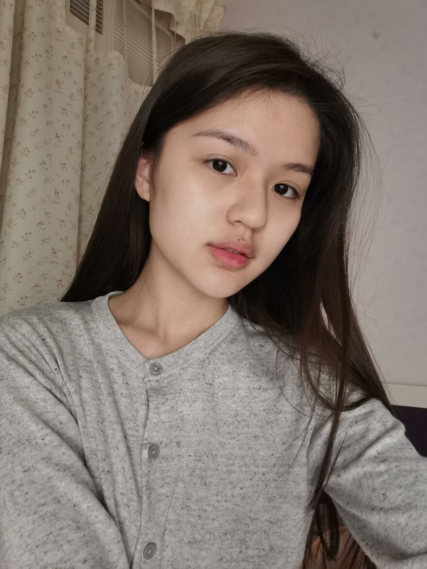 Young Asian woman with long hair wearing a gray sweater, representing diversity beyond common Asian stereotypes.