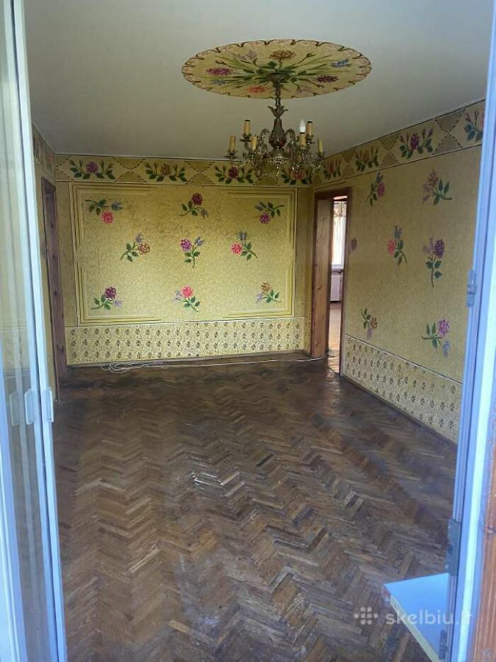 Empty room with floral wallpaper and chandelier, part of wild real estate listings that people thought would help sell properties.