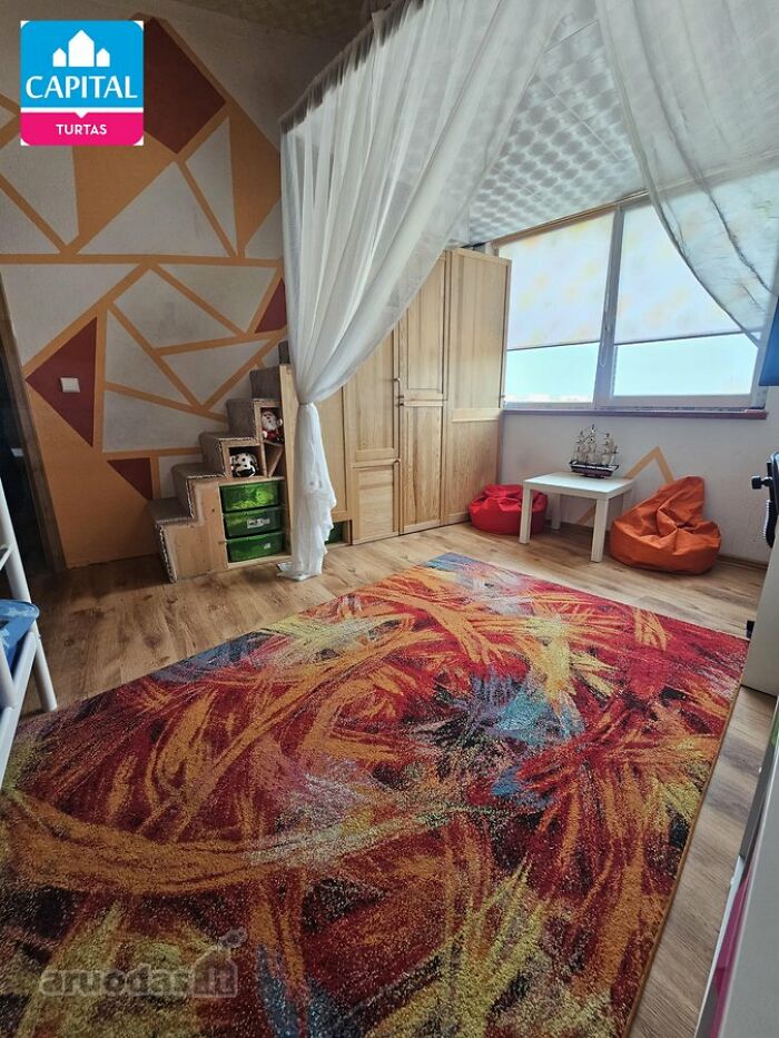 Colorful kids' room with bean bags, wooden furniture, and a vibrant rug in wild real estate listings to sell properties.