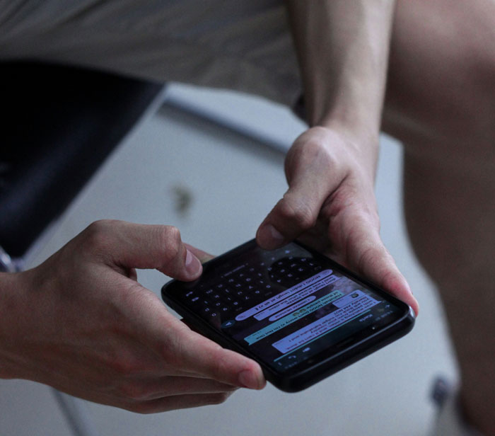 Person holding smartphone displaying text messages, illustrating an Oscar-worthy performance of believable lies.