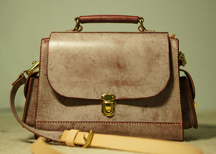 Worn vintage handbag with gold clasp and strap, representing horrible gifts people have actually received.