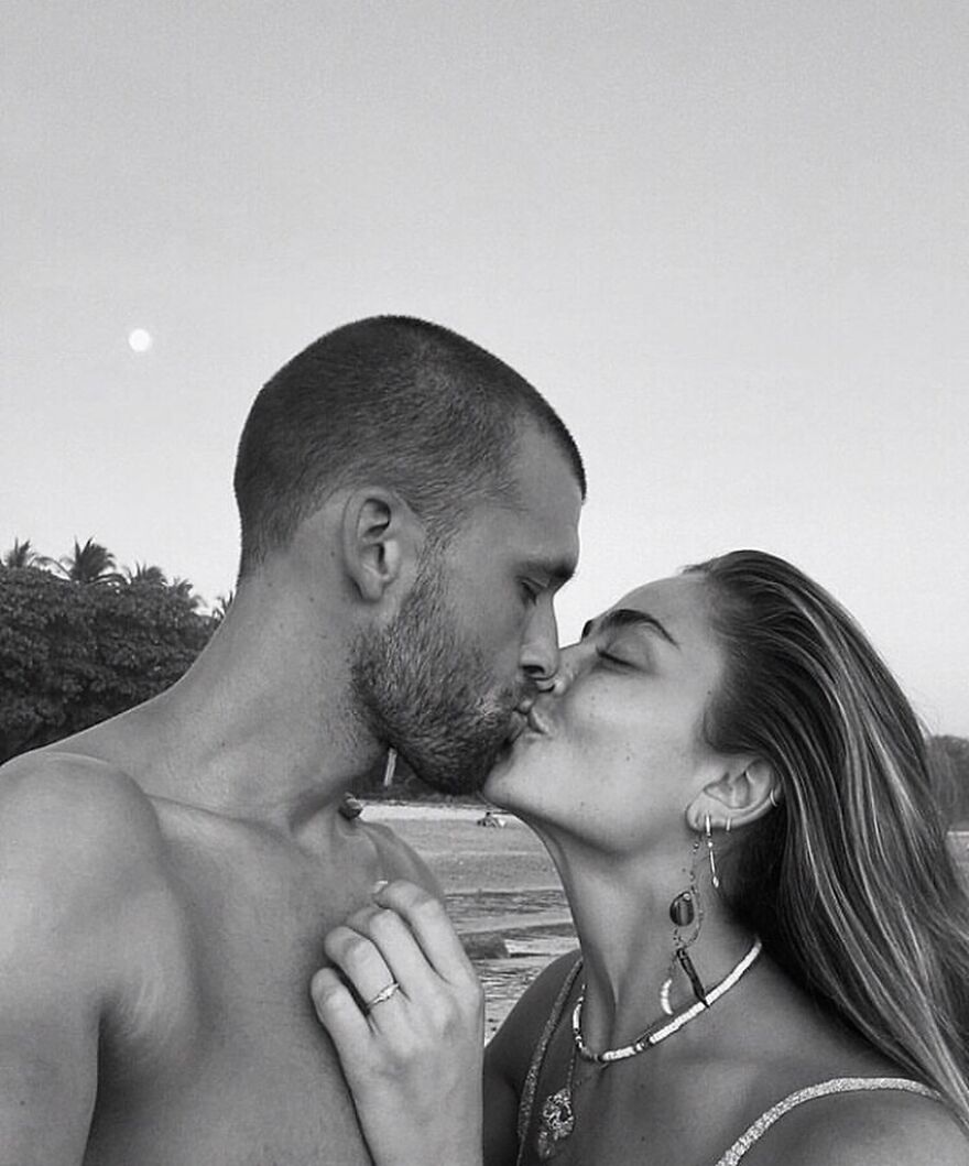Couple sharing a romantic kiss on the beach, illustrating types of kisses in culture and history.