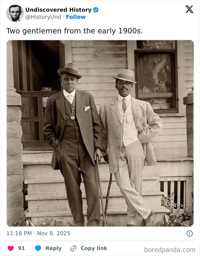 Two gentlemen from the early 1900s standing on a porch, captured in a fascinating photo revealing moments lost to time.