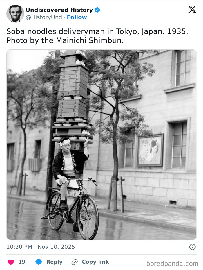 Soba noodles deliveryman in Tokyo balancing stacked boxes on his head while riding a bicycle in 1935, a moment lost to time.