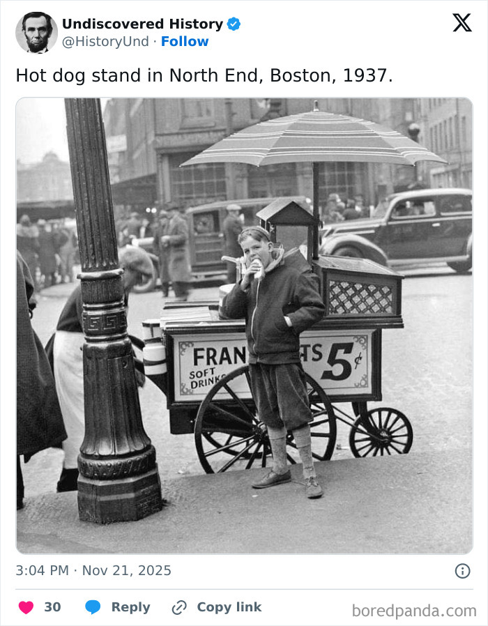 Boy eating hot dog at vintage Boston street stand in 1937, a fascinating photo revealing moments lost to time.