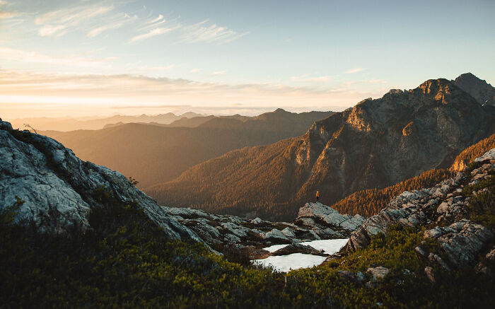 Person standing on a rocky mountain at sunrise, reflecting on finding purpose through a personal journey. Person standing on a rocky mountain at sunrise, reflecting on finding purpose through a personal journey.