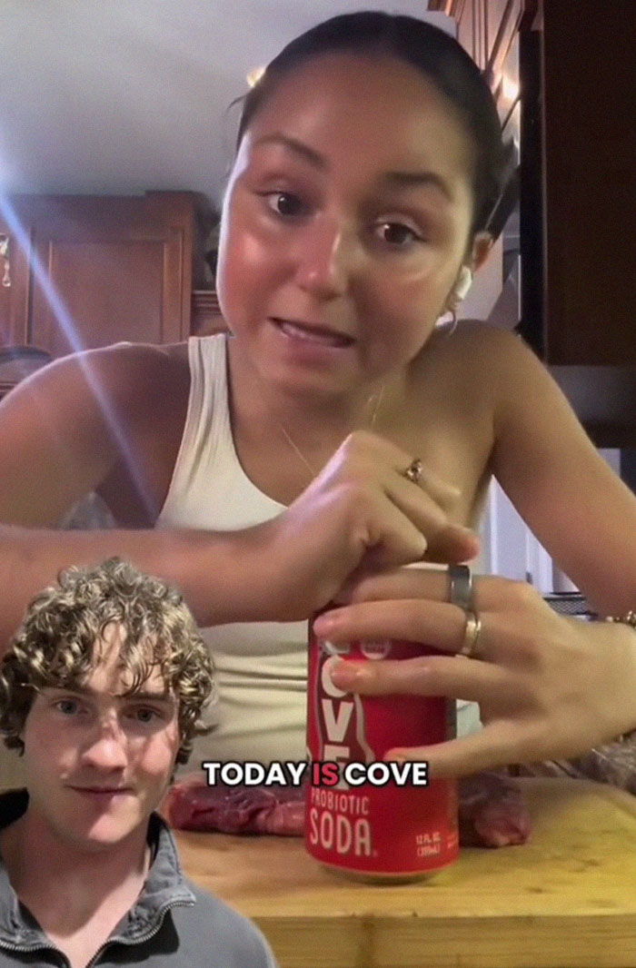 Young woman opening a probiotic soda can while sharing wild American food creations that traumatized the internet. Young woman opening a probiotic soda can while sharing wild American food creations that traumatized the internet.