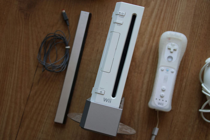 White Nintendo Wii console with remote and sensor bar on wooden surface, illustrating stories about people not deserving nice things.