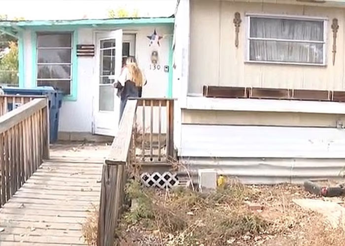 Woman entering a weathered house with a wooden ramp, scene related to missing woman’s body discovered in garage case.