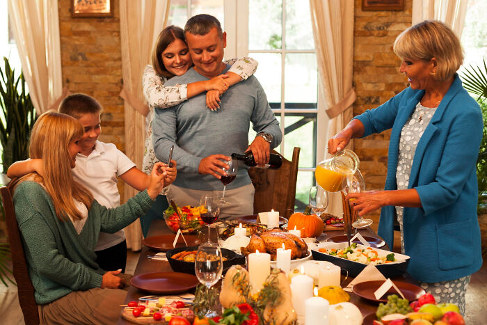 Family enjoying Thanksgiving dinner together with mashed potatoes and vibrant dishes around the table during holiday gathering.