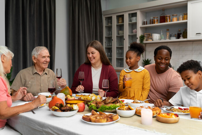 Multigenerational family sharing a Thanksgiving meal with mashed potatoes and traditional dishes around the dining table.