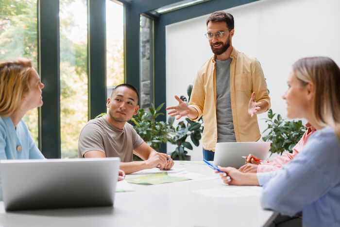 Group of young professionals discussing compulsory things in life were optional during an informal meeting by the window.