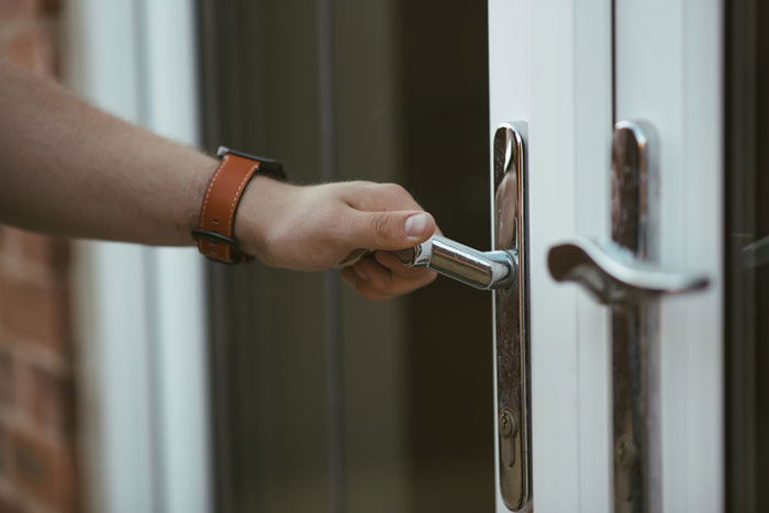 Person with leather strap watch opening a door handle, illustrating entitled parents and autistic brother dynamics.