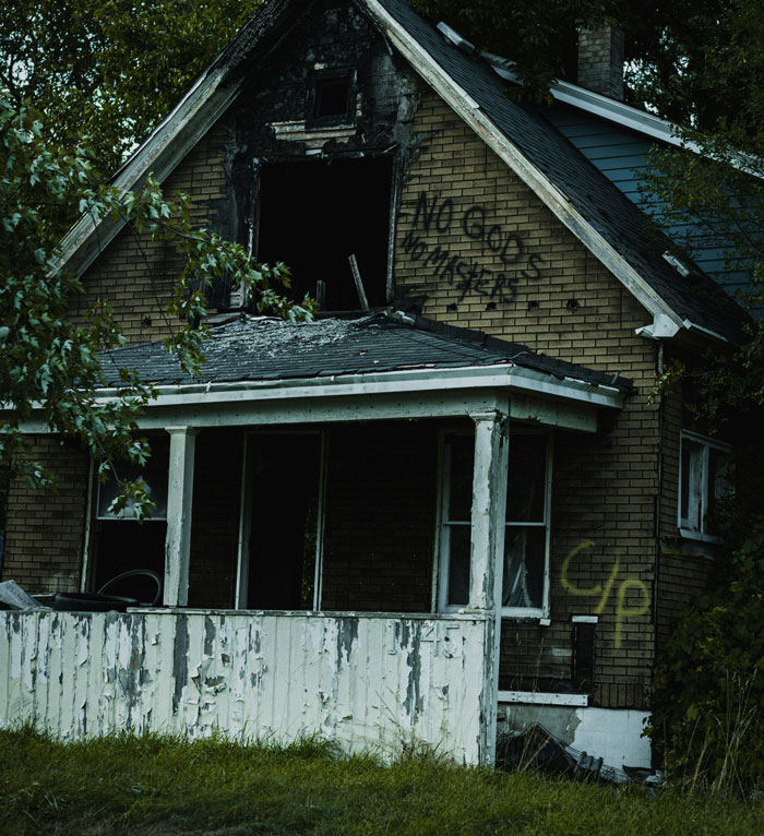 Abandoned house with boarded windows and graffiti, evoking creepy and terrifying moments in urban exploration.