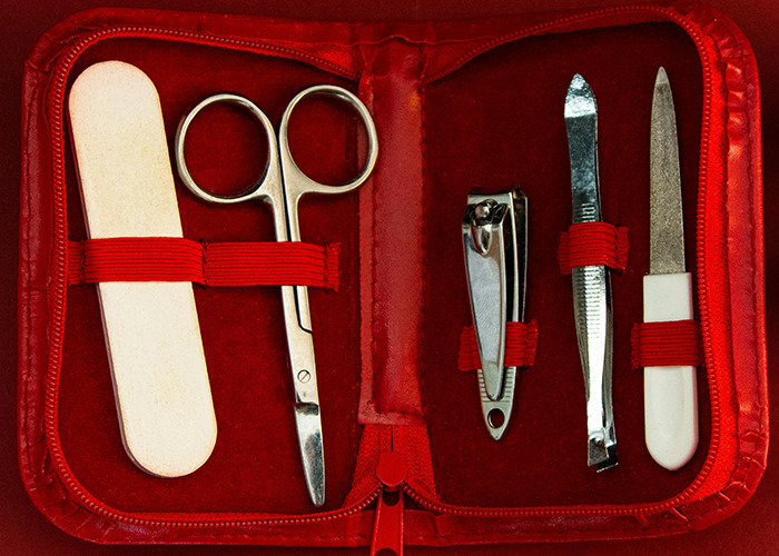 Manicure set with scissors, nail clippers, file, and buffer in a red case, representing horrible gifts people describe receiving.