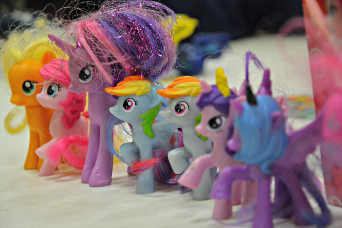 Colorful collectible toy ponies with various manes and wings lined up on a table in a comically absurd facts setting.