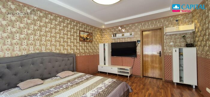 Bedroom with vintage wallpaper and wooden flooring featured in wild real estate listings for unique property sales.