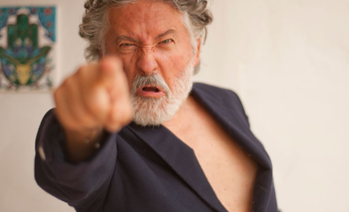 Angry older man with gray hair and beard pointing at camera, capturing intense family drama emotion online.