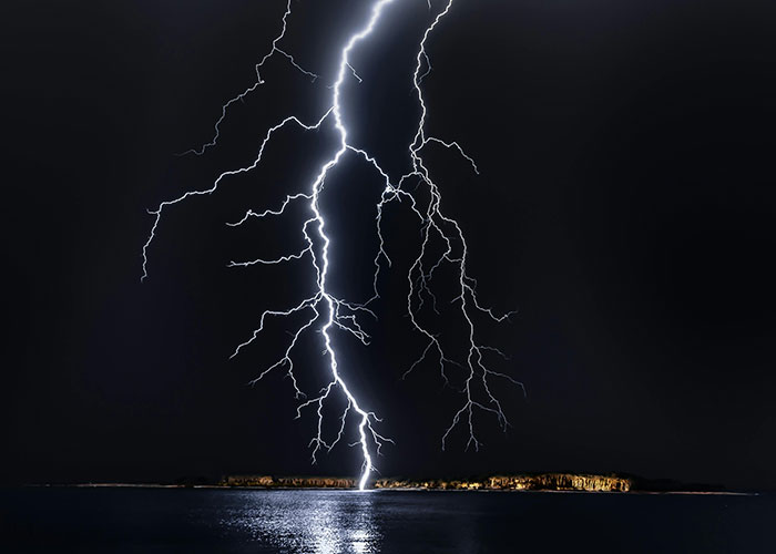 Bright lightning striking an island at night, illustrating common knowledge facts that blow people's minds.