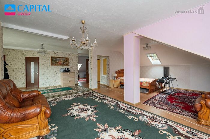 Spacious living area in a wild real estate listing featuring vintage furniture, decorative rugs, and unique interior design.