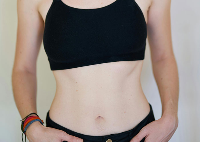 Close-up of a person’s midsection wearing a black crop top and black pants, highlighting common knowledge revealed.