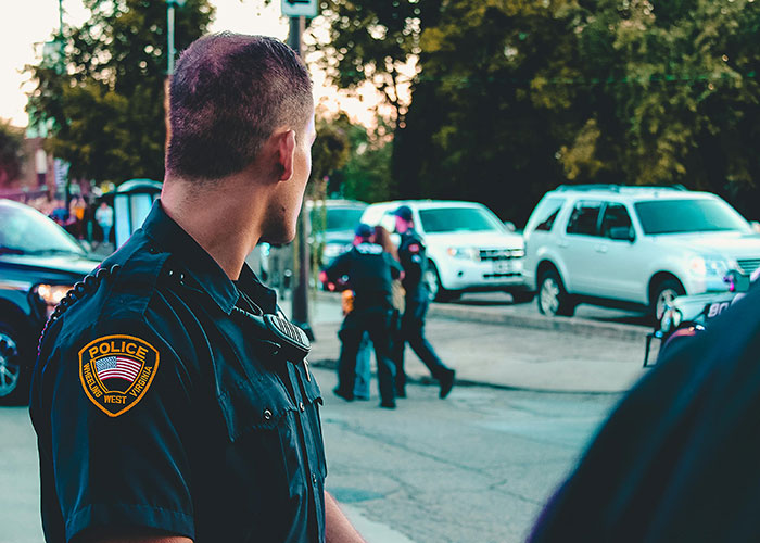Police officer outside a psychiatric institution with others in the background experiencing unforgettable moments on the job