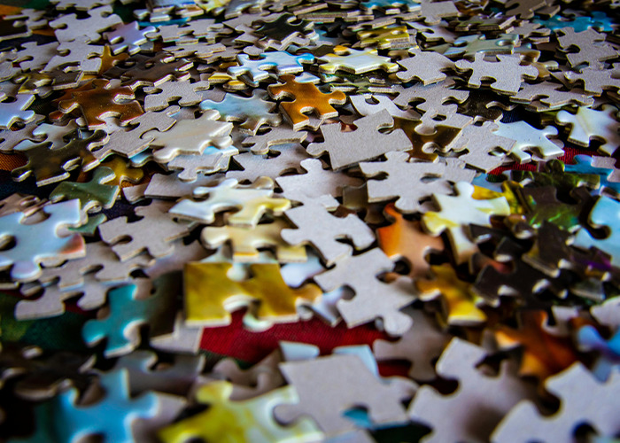 Scattered jigsaw puzzle pieces representing the concept of horrible gifts people have actually received.