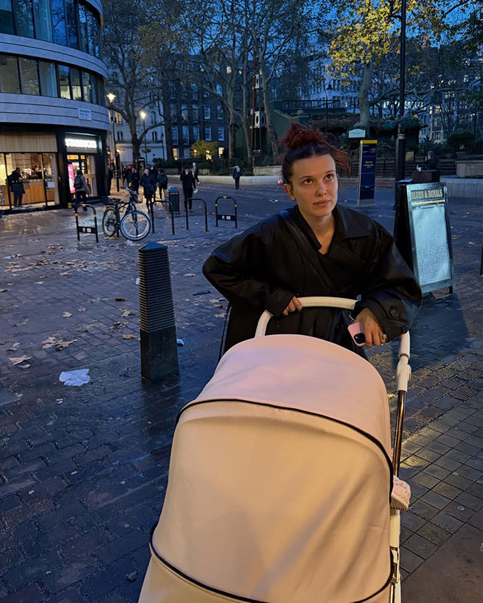 Millie Bobby Brown pushing a stroller outdoors in the evening amid fans furious over her legal name change news. Millie Bobby Brown pushing a stroller outdoors in the evening amid fans furious over her legal name change news.