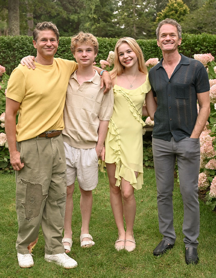 Neil Patrick Harris and family posing outdoors in casual clothing, capturing a joyful moment together. Neil Patrick Harris and family posing outdoors in casual clothing, capturing a joyful moment together.