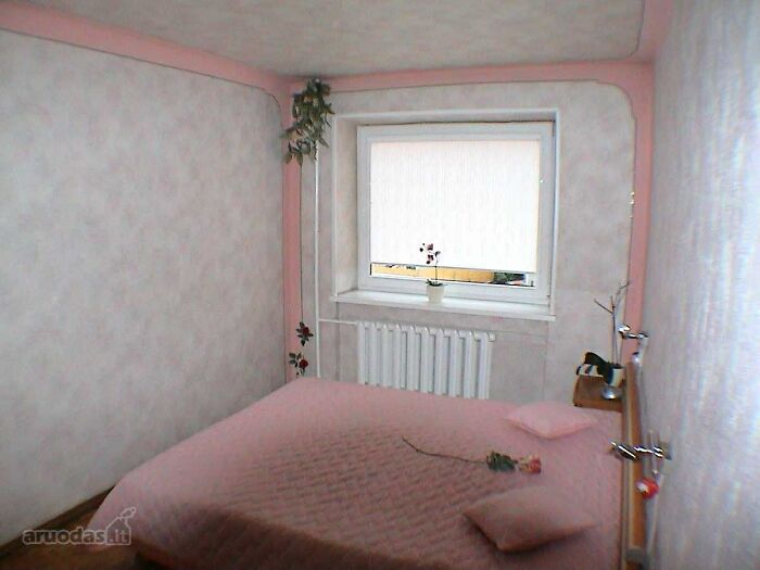 Small bedroom with pink bedding and minimal decor, an example of wild real estate listings for property sale.