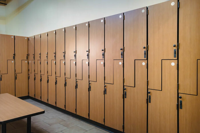 Locker room at Gold's Gym with wooden lockers and benches, relevant to backlash after lesbian confronted trans woman incident Locker room at Gold's Gym with wooden lockers and benches, relevant to backlash after lesbian confronted trans woman incident