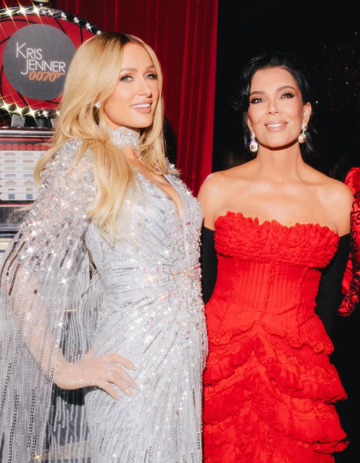 Two elegantly dressed women at Kris Jenner's 70th birthday bash guest list event, stunning fans with notable attendees.