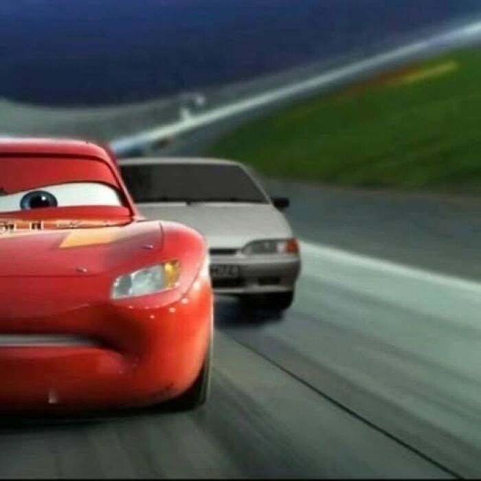 Animated red race car leading a grey car on a race track, showcasing dynamic action in popular pics that go hard.